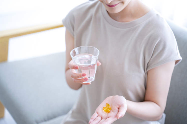 サプリを飲む女性