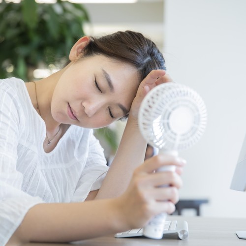 ハンディ扇風機を使う女性
